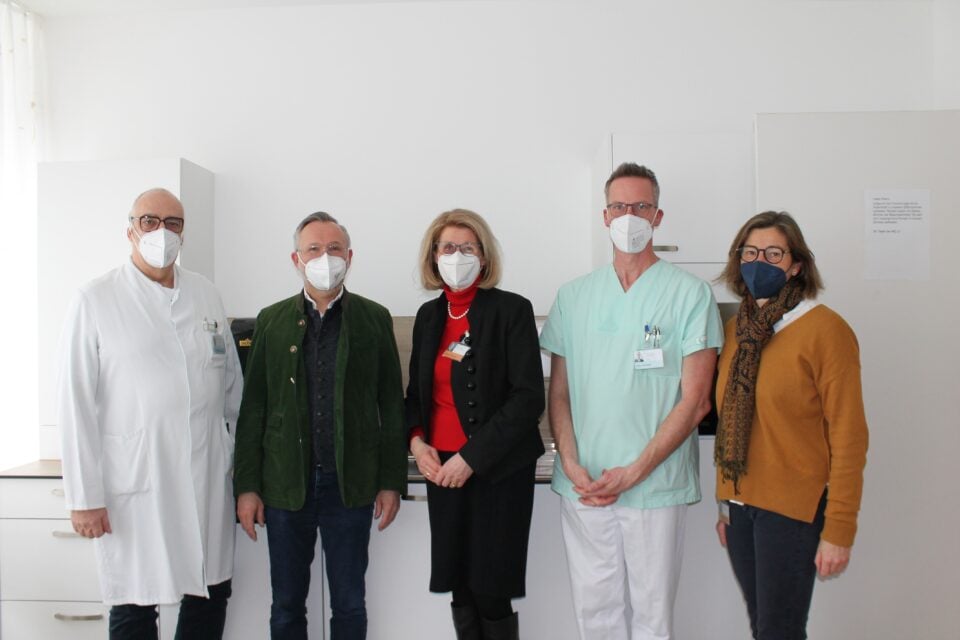 5 Menschen mit Maske in Krankhhaus, stehen nebeneinander